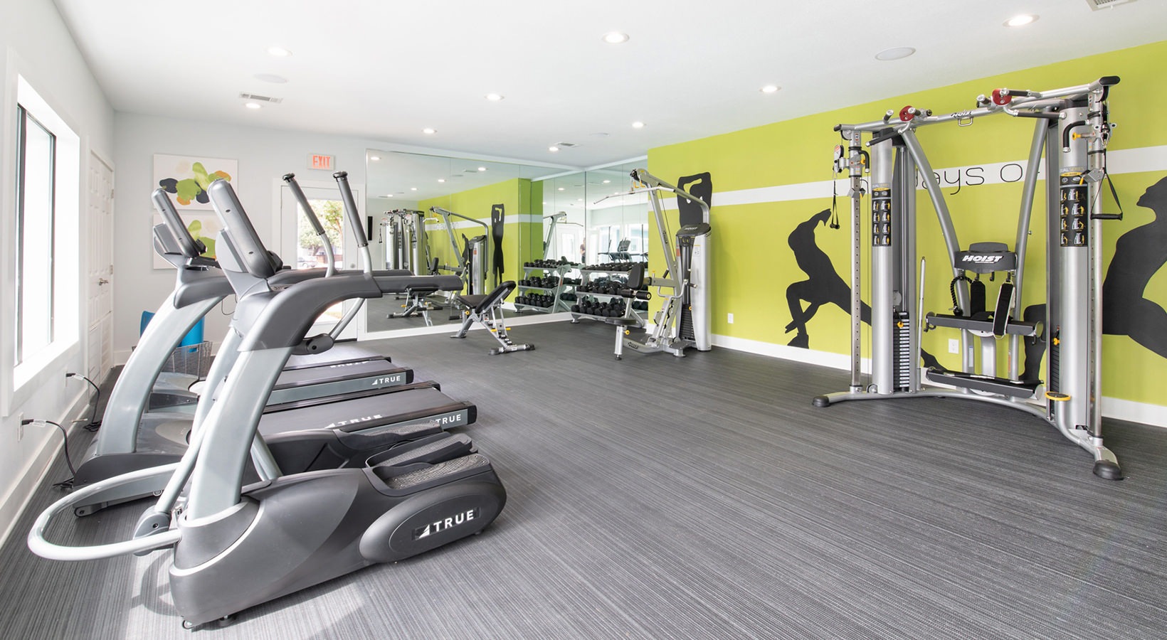 a gym room with tread machines and exercise equipment at The Maxwell