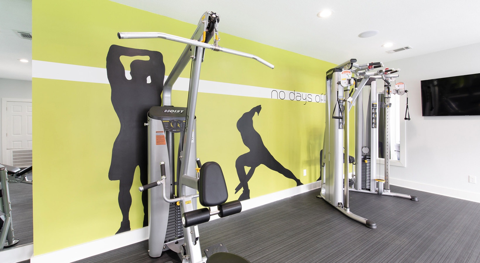 a gym room with a wall mural and equipment at The Maxwell