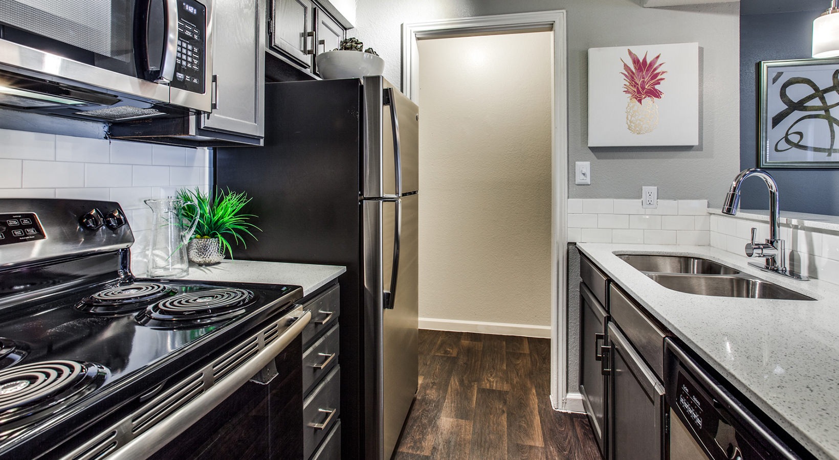 kitchen with stainless steel appliances and black cabinets at The Maxwell