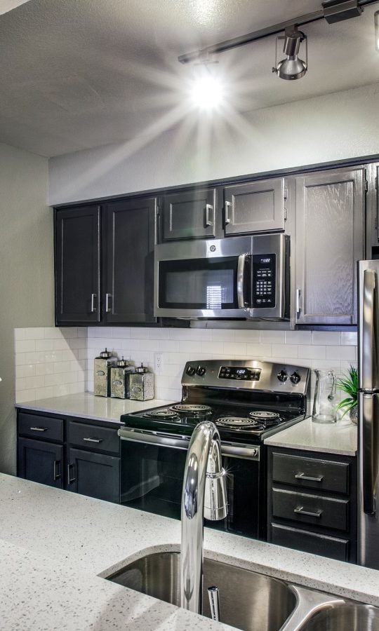 kitchen with stainless steel appliances and granite countertops at The Maxwell