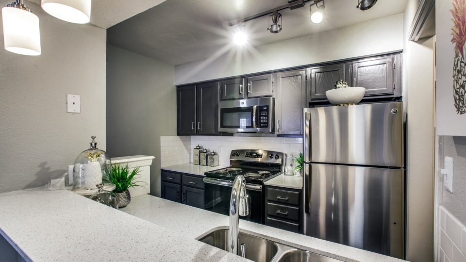 kitchen with stainless steel appliances and granite countertops at The Maxwell