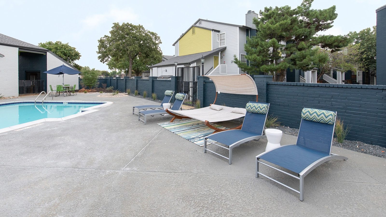 a pool and lounge chairs in front of a house at The Maxwell