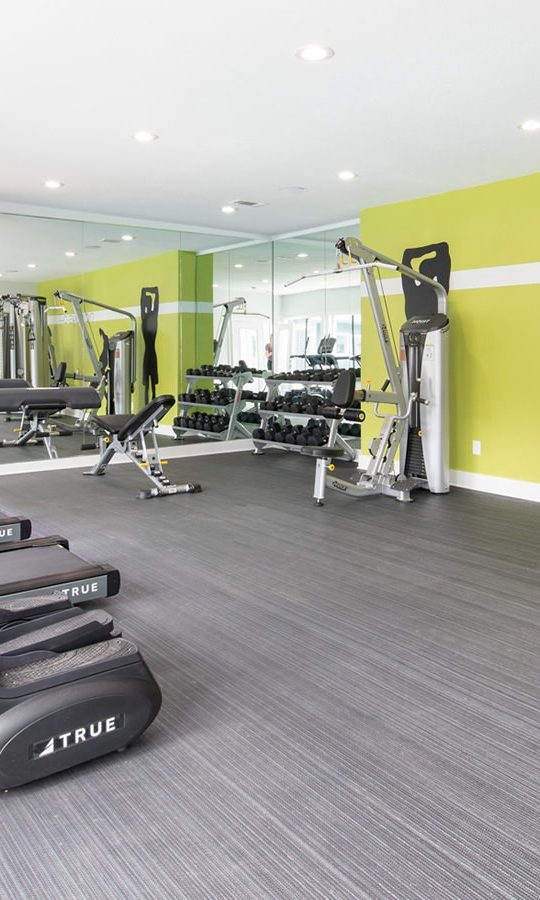 a gym room with tread machines and exercise equipment at The Maxwell