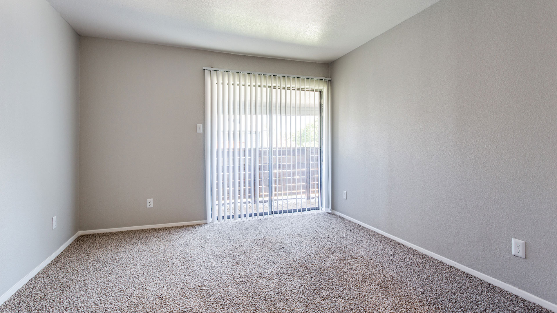 empty room with carpet and sliding glass door at The Maxwell