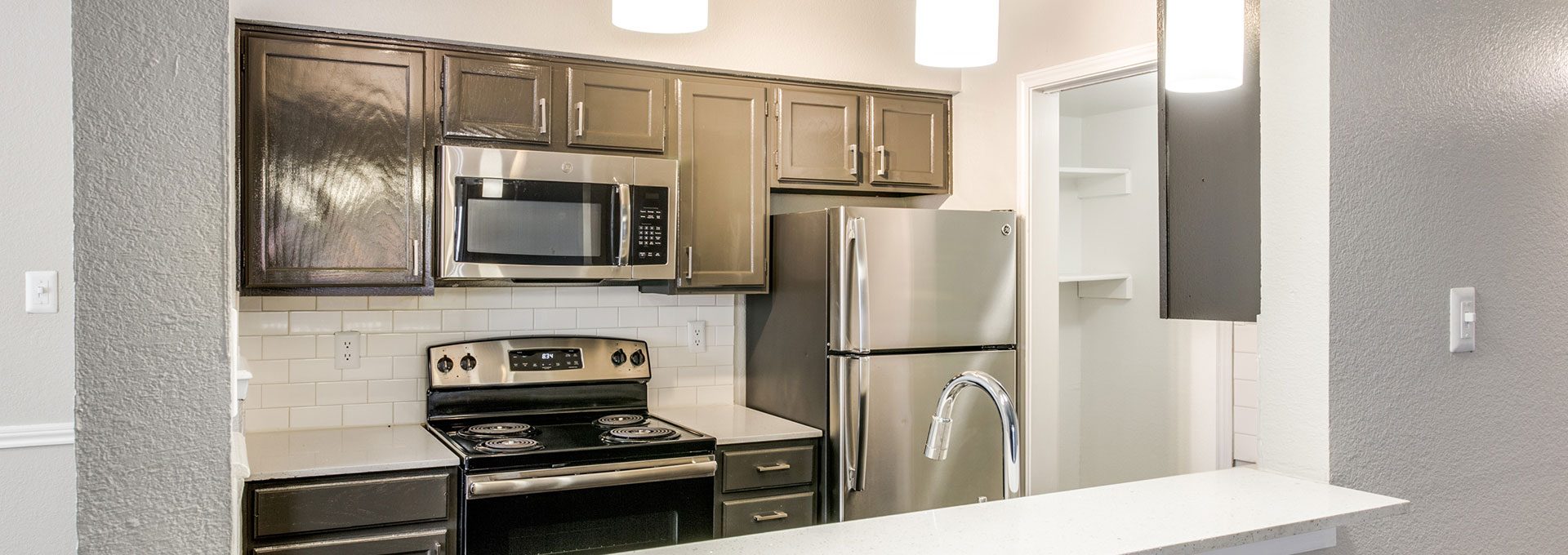 a kitchen with stainless steel appliances and a microwave at The Maxwell