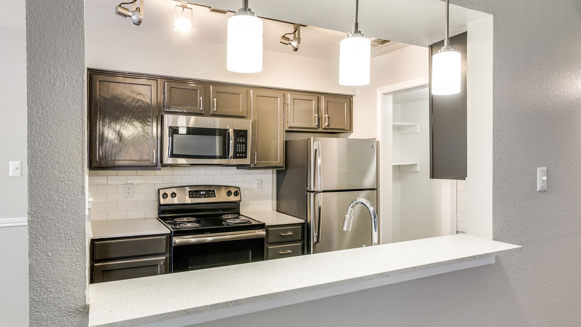 a kitchen with stainless steel appliances and a microwave at The Maxwell